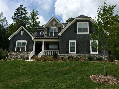 dark green house with gray metal roof|gray exterior with black trim.